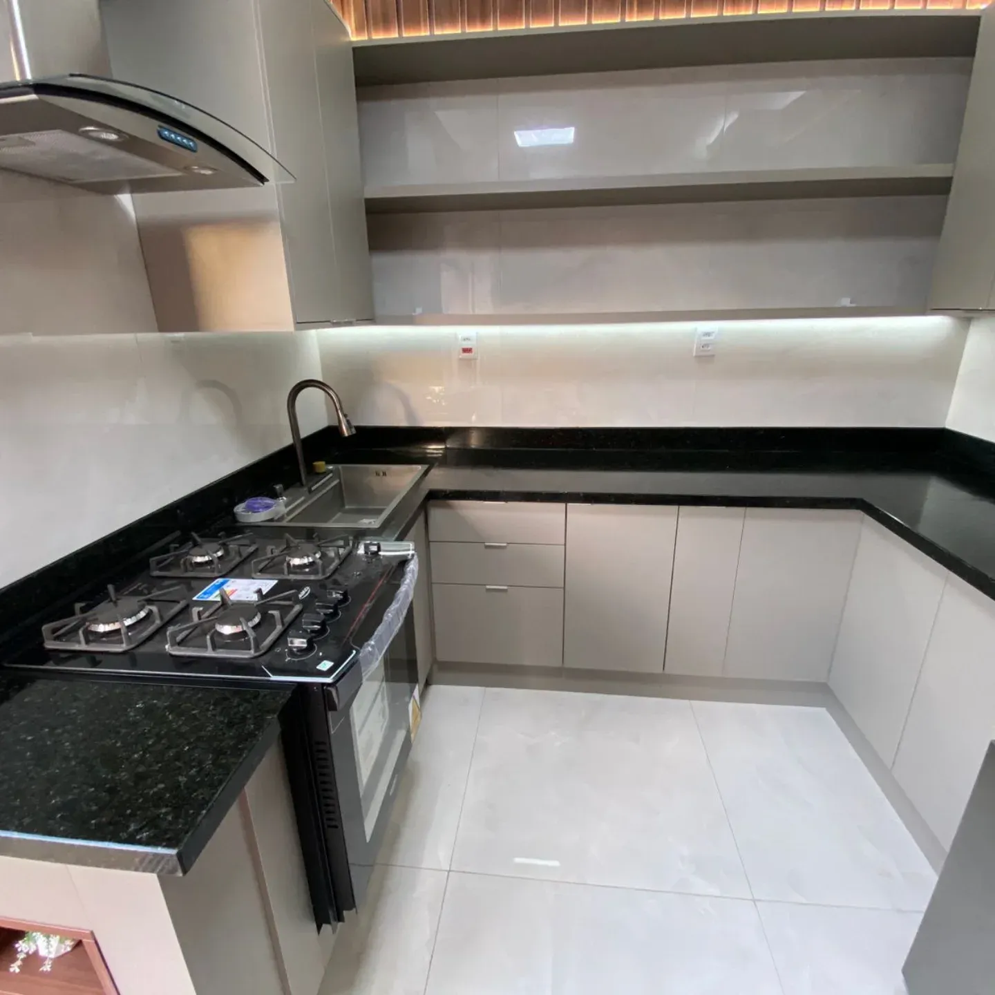 Cozinha com bancada em granito preto e cooktop embutido