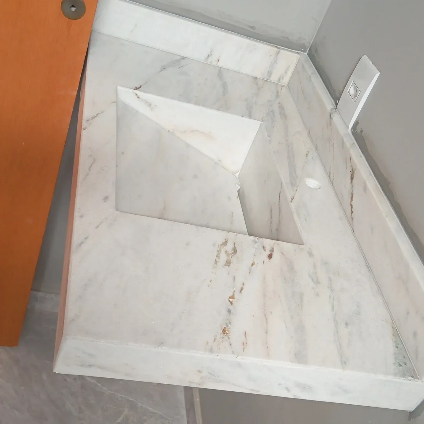 Bancada de banheiro em mármore branco com cuba esculpida